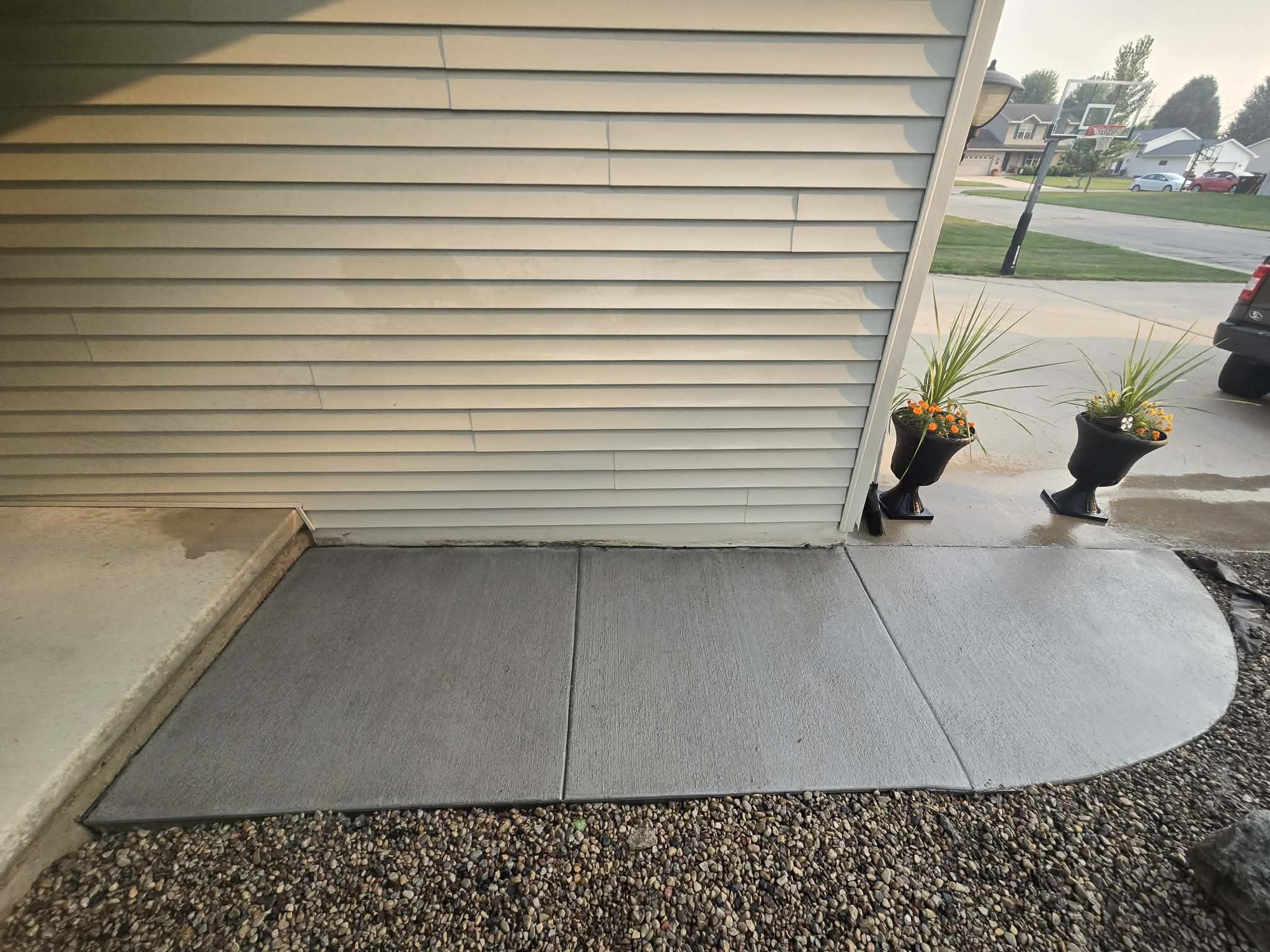 Fresh broom-finish concrete walkway beside a garage